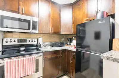 a kitchen with wooden cabinets and a stainless steel refrigerator at Tropical Oasis Getaway in Miami Beach