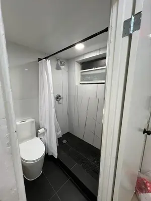 a small bathroom with a toilet and a shower at Tropical Oasis Getaway in Miami Beach