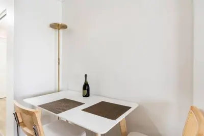 a white dining room table with a bottle of wine on it at Tropical Oasis Getaway in Miami Beach