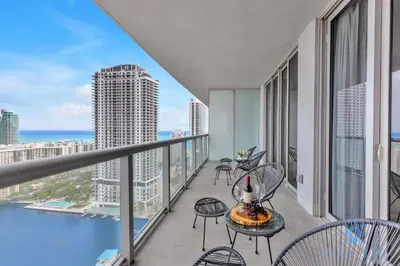 a balcony with chairs and tables and a view of the ocean at Amazing View - Pool - Gym - 2 Bedrooms in Hallandale Beach