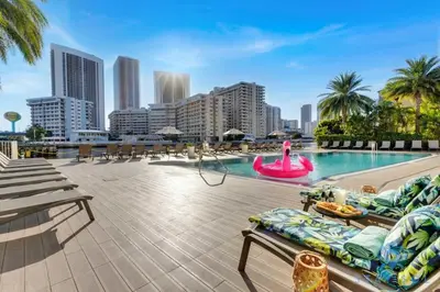 a large swimming pool with a city skyline in the background at Upper Apartment - Pool - Gym - Near Beach in Hallandale Beach