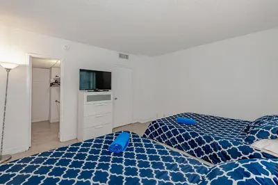 a bedroom with a blue bed and a television at Hollywood on The Beach in Hollywood