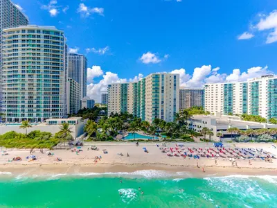 a beach with people in the water and buildings at Hollywood on The Beach in Hollywood