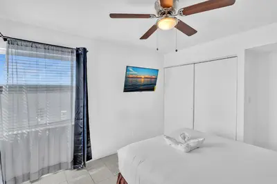 a bedroom with a ceiling fan and a bed at Coastal Sunset in Hollywood