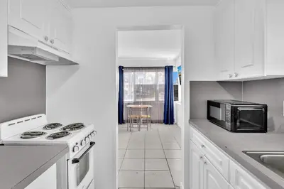 a white kitchen with a microwave and a stove at Coastal Sunset in Hollywood