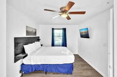 a white bedroom with a bed and a ceiling fan at Coastal Sunset in Hollywood