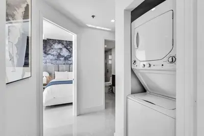 a white room with a bed and a mirror at Luxe Brickell Gem with Huge Balcony n Ocean Views in Miami