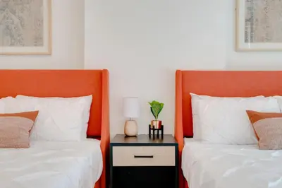 two beds with orange headboards next to a table with a lamp at Stylish 1BR APT with Ocean and City view,pool,parking in Miami