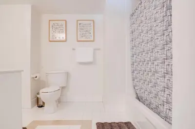 a bathroom with a toilet and a tile wall at Stylish 1BR APT with Ocean and City view,pool,parking in Miami