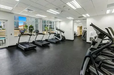 a gym with treadmills and elliptical machines at Stylish 1BR APT with Ocean and City view,pool,parking in Miami