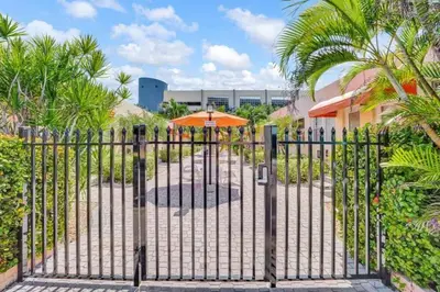 an open gate with an orange umbrella at Chic Studio Apartment in Hollywood Beach in Hollywood