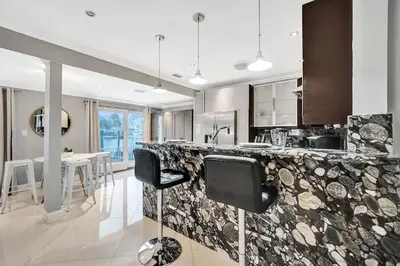 a kitchen with a counter with chairs and a table at Beach Isles Modern 1BR Waterfront Apartment with Patio in Fort Lauderdale