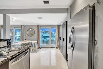 a kitchen with a stainless steel refrigerator at Beach Isles Modern 1BR Waterfront Apartment with Patio in Fort Lauderdale