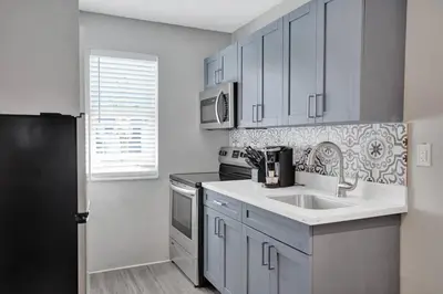 a kitchen with a sink and a black refrigerator at Rustic Retreats Beachy 1BR for 4 guests in the heart of Fort Lauderdale in Fort Lauderdale