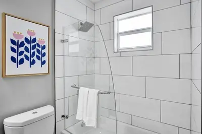 a bathroom with a shower and a toilet and a window at Rustic Retreats Beachy 1BR for 4 guests in the heart of Fort Lauderdale in Fort Lauderdale