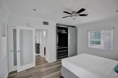 a white bedroom with a bed and a ceiling fan at Beach Isles Modern 1BR Apartment in Fort Lauderdale in Fort Lauderdale