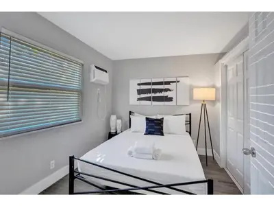 a bedroom with a large white bed with a window at Rustic Retreats Beachy 1BR for 4 guests in the heart of Fort Lauderdale in Fort Lauderdale