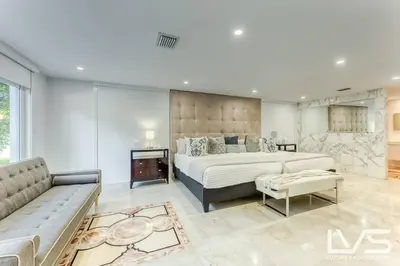 a large bedroom with a large bed and a couch at Cascada-Luxe Resort Heated Pool HotTub Wlk 2 Beach in Fort Lauderdale