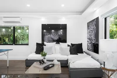 a living room with two beds and a table at Villa Arielle in Miami