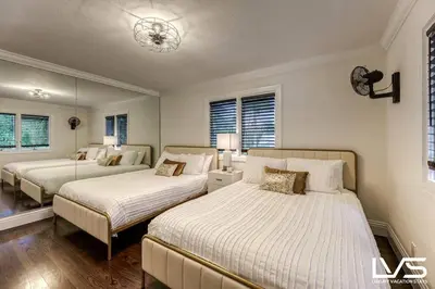 a bedroom with two beds and a mirror at Poinciana-LuxeHome Wlk2Beach HeatedPool HotTub in Fort Lauderdale
