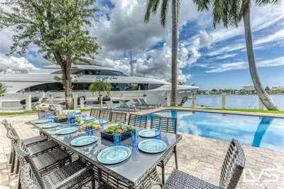 a table with plates of food next to a yacht at VillaKey- LUXE Waterfront Villa 5Min to Beach in Fort Lauderdale