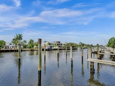 a dock in a body of water with houses at Beach Isles Modern 1BR in Fort Lauderdale with Patio in Fort Lauderdale