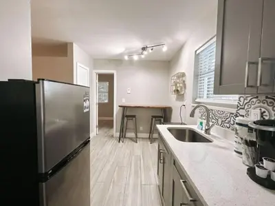 a kitchen with a stainless steel refrigerator and a table at Rustic Retreats Modern 1BR for 4 guests in the heart of Fort Lauderdale in Fort Lauderdale