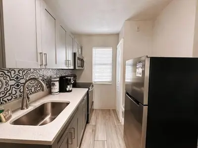 a kitchen with a sink and a stainless steel refrigerator at Rustic Retreats Cozy 1BR For 4 Guests Minutes From Las Olas in Fort Lauderdale