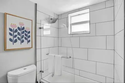 a bathroom with a shower and a toilet and a window at Rustic Retreats Modern 1BR For 4 Guests Minutes From Las Olas in Fort Lauderdale