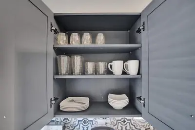 a walk in pantry with white dishes and plates at Rustic Retreats Spacious 1BR For 4 guests In The Heart of Fort Lauderdale in Fort Lauderdale