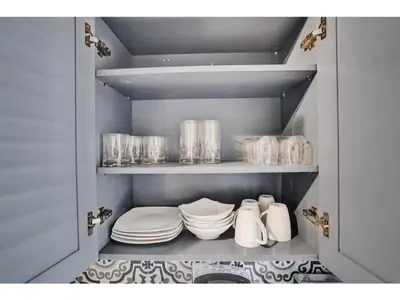 a cupboard filled with plates and dishes in a kitchen at Rustic Retreats Spacious 1BR For 4 guests In The Heart of Fort Lauderdale in Fort Lauderdale