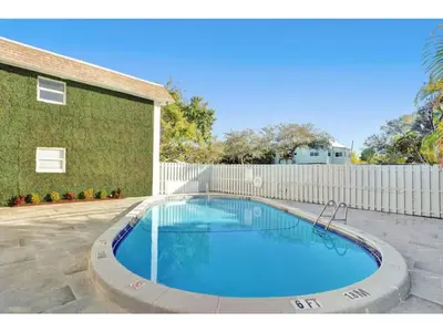 a large swimming pool in front of a building at Rustic Retreats Cozy 1BR For 4 Guests In The Heart Of Fort Lauderdale in Fort Lauderdale