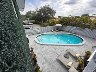 a swimming pool with patio furniture and a fence at Rustic Retreats Cozy 1BR for 4 guests minutes from Las Olas in Fort Lauderdale