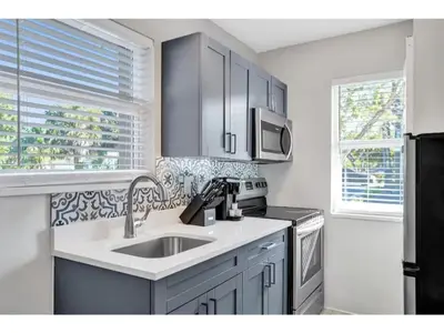 a kitchen with a sink and a refrigerator at Rustic Retreats Cozy 1BR for 4 guests minutes from Las Olas in Fort Lauderdale