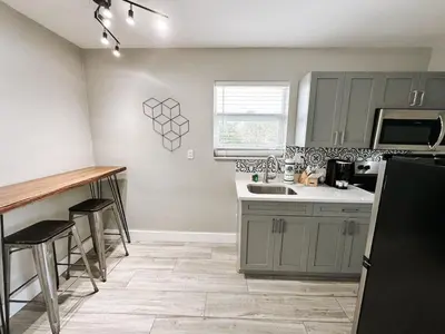 a kitchen with gray cabinets and a counter top at Rustic Retreats Cozy 1BR for 4 guests minutes from Las Olas in Fort Lauderdale