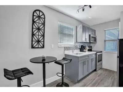 a kitchen with a sink and a table with stools at Rustic Retreats Modern 1BR for 4 guests in the heart of Fort Lauderdale in Fort Lauderdale