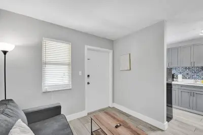 a living room with a couch and a kitchen at Rustic Retreats Cozy 1BR For 4 Guests Minutes From Las Olas in Fort Lauderdale