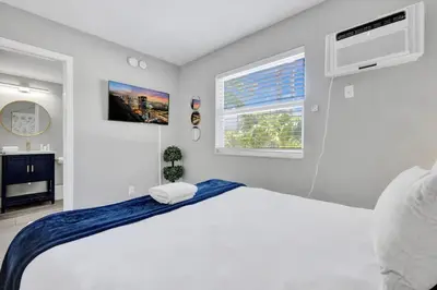 a white bedroom with a bed and a window at Rustic Retreats Cozy 1BR For 4 Guests Minutes From Las Olas in Fort Lauderdale
