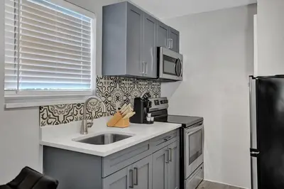 a kitchen with a sink and a microwave at Rustic Retreats Cozy 1BR For 4 Guests In The Heart Of Fort Lauderdale in Fort Lauderdale