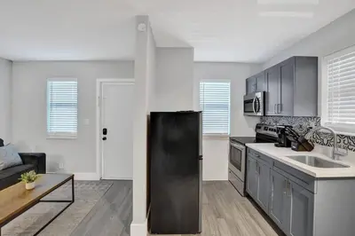 a kitchen with a black refrigerator in a room at Rustic Retreats Beachy 1BR for 4 guests in the heart of Fort Lauderdale in Fort Lauderdale