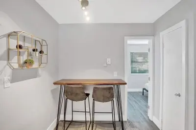 a kitchen with a wooden table and two stools at Rustic Retreats Beachy 1BR for 4 guests in the heart of Fort Lauderdale in Fort Lauderdale