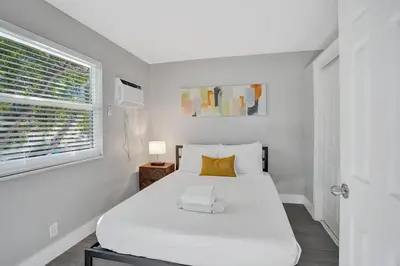 a white bedroom with a white bed and a window at Rustic Retreats Cozy 1BR for 2 guests minutes from Las Olas in Fort Lauderdale