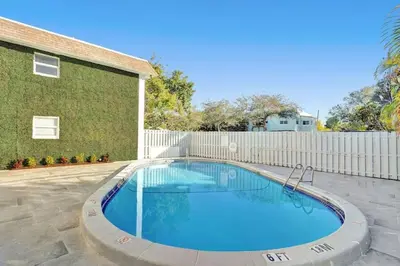 a swimming pool in front of a building at Rustic Retreats Cozy 1BR for 2 guests minutes from Las Olas in Fort Lauderdale