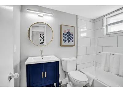 a white bathroom with a toilet and a sink at Rustic Retreats Modern 1BR for 2 guests in the heart of Fort Lauderdale in Fort Lauderdale
