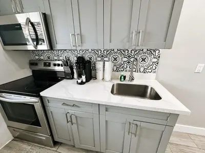 a white kitchen with a sink and a microwave at Rustic Retreats Modern 1BR for 4 guests in the heart of Fort Lauderdale in Fort Lauderdale