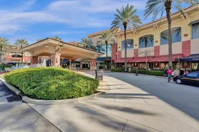 a street in front of a shopping mall with palm trees at Rustic Retreats Modern 1BR for 4 guests in the heart of Fort Lauderdale in Fort Lauderdale