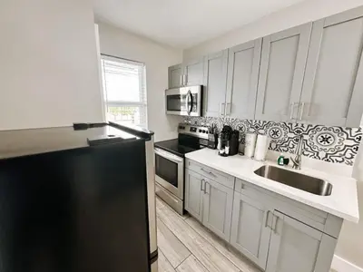 a kitchen with a black refrigerator and a sink at Rustic Retreats Modern 1BR for 4 guests in the heart of Fort Lauderdale in Fort Lauderdale