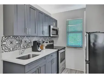 a kitchen with a sink and a stainless steel refrigerator at Rustic Retreats Beachy 1BR for 4 guests in the heart of Fort Lauderdale in Fort Lauderdale
