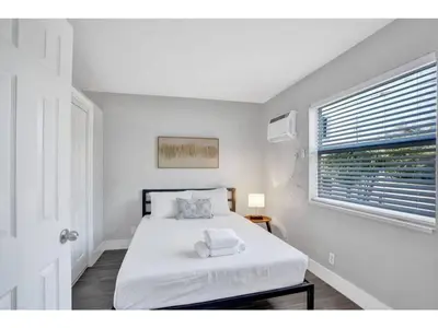 a white bedroom with a bed and a window at Rustic Retreats Beachy 1BR for 4 guests in the heart of Fort Lauderdale in Fort Lauderdale