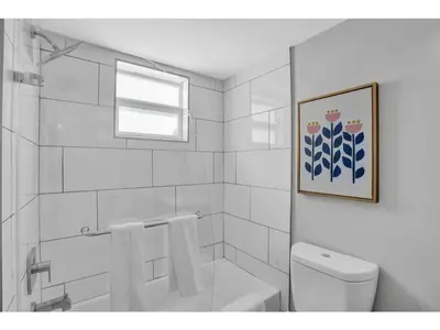 a white bathroom with a toilet and a window at Rustic Retreats Beachy 1BR for 4 guests in the heart of Fort Lauderdale in Fort Lauderdale